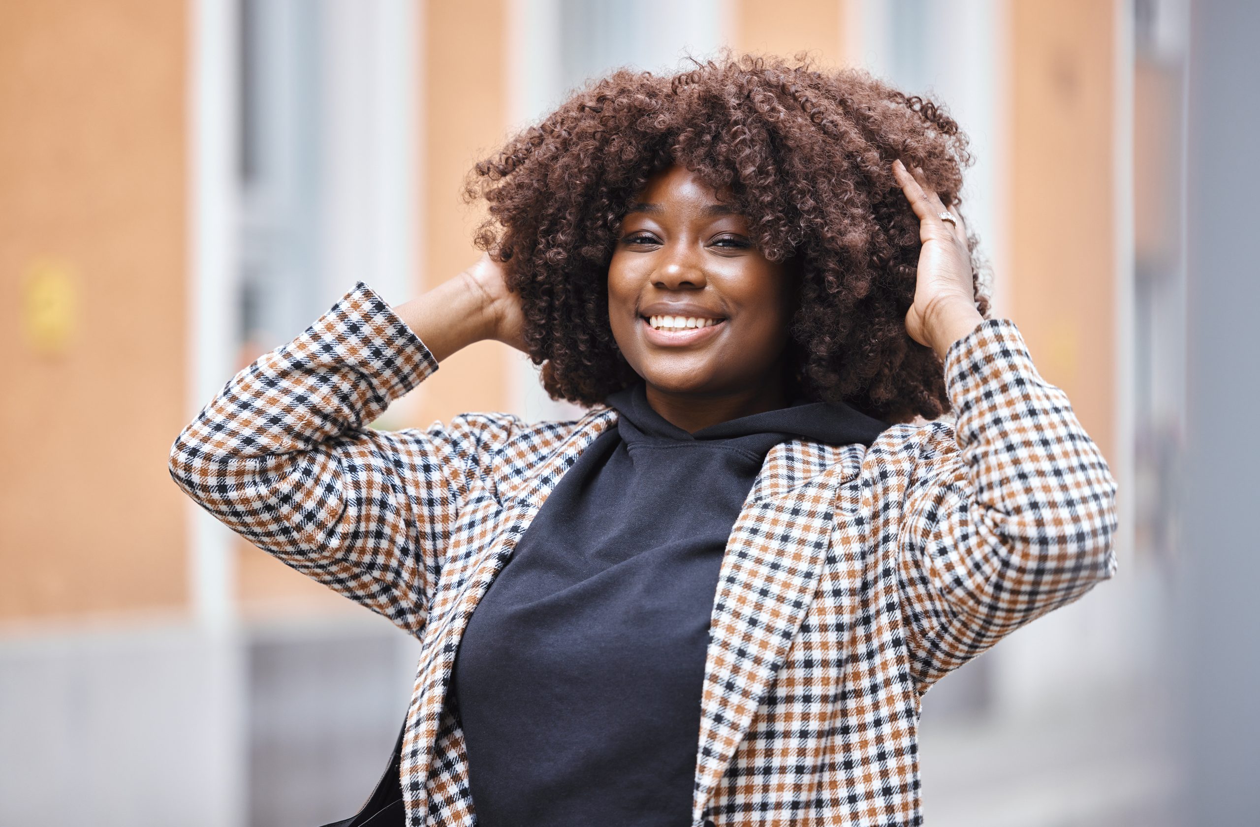 stylish woman smiles with hands in curly hair 2026 01 09 11 13 21 utc